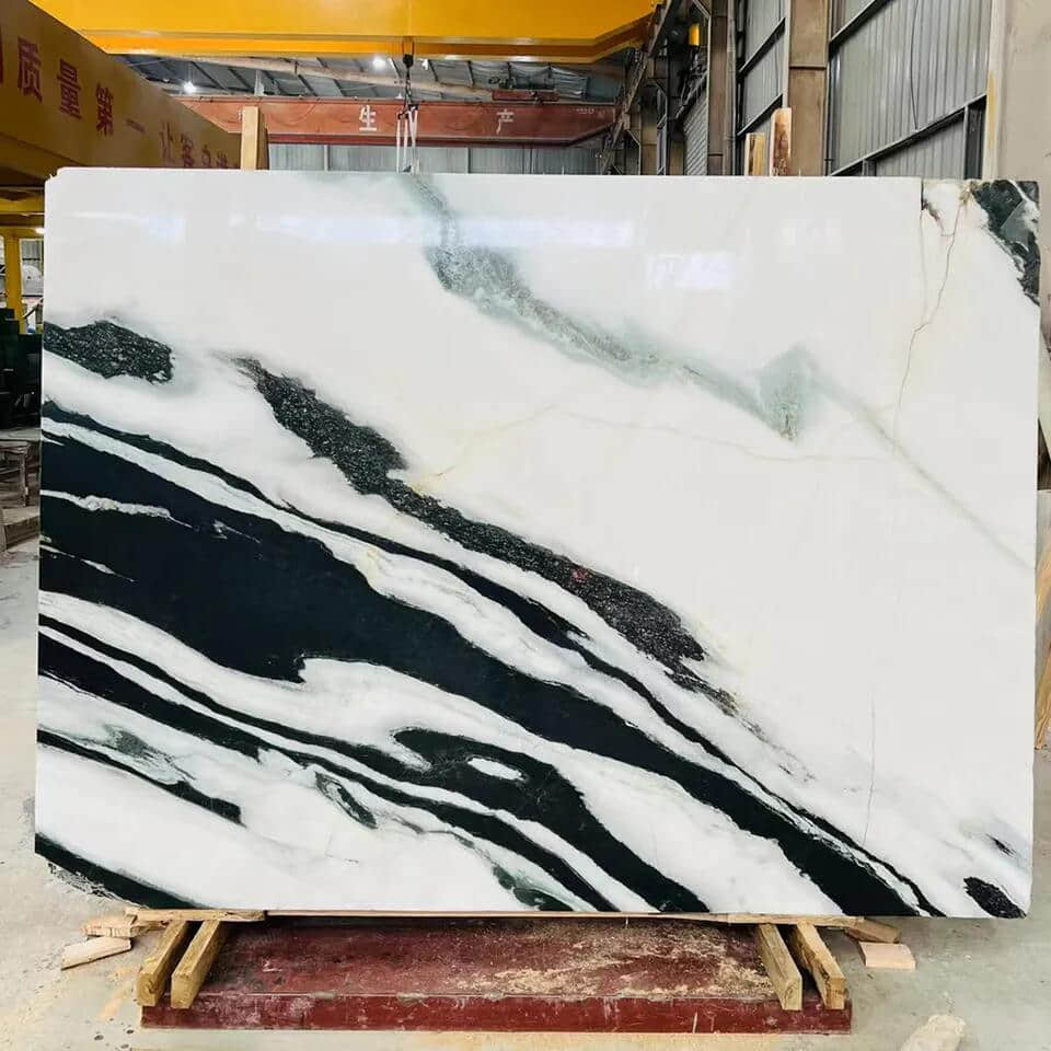 O Panda White Marble, uma pedra natural originária da China, é uma obra-prima cativante da natureza, com sua base de pele branca pura e texturas fluidas em cor de tinta. Sua mistura exclusiva de preto e branco cria uma dança poética, que lembra as pinturas a tinta de Wu Guanzhong&#039. Esse mármore é adequado para aplicações residenciais e comerciais, oferecendo durabilidade, opções de personalização, sustentabilidade e considerações ambientais. Sua textura uniforme e luminosidade o tornam uma opção versátil para vários projetos de design, como paredes de fundo, degraus de escada e transmissão de luz. O fascínio e o talento artístico do Panda White Marble&#039 o tornam a escolha ideal para vários projetos de design, deixando uma impressão duradoura em qualquer espaço.